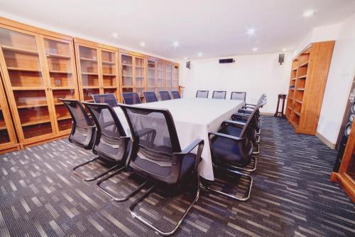 a conference room with a white table and black chairs at The Charter House in Manila