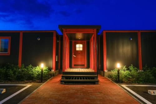 a house with a red door at night at Phottage inn Biei in Biei