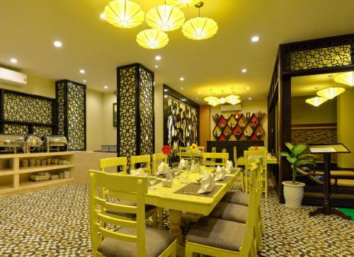 un ristorante con tavoli e sedie gialli e lampadari a braccio di River Suites Hoi An a Hoi An