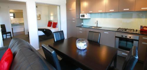 a kitchen with a table and a couch in a room at Swiss-Belsuites Pounamu Queenstown in Queenstown