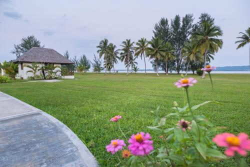 a garden with pink flowers and a gazebo at Beachfront Resort in Luganville