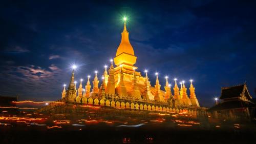 a large building with lights on it at night at Intouch Guest House in Vientiane