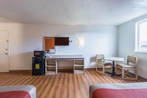 a room with a desk and a table and chairs at Motel 6-Beaverton, OR in Beaverton