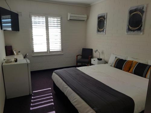 a bedroom with a large bed and a window at Morphett Arms Hotel in Adelaide