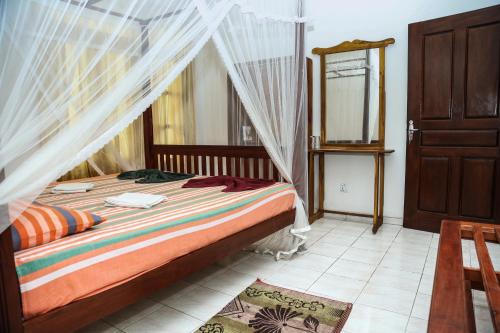 a bedroom with a bed with a mosquito net at Resort Deepika Mirissa in Mirissa