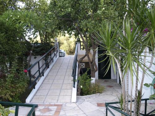 a staircase leading up to a house with trees and plants at Kastro Studios Apartments in Myrtos