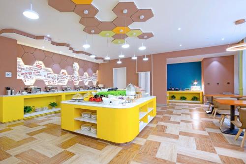 a kitchen with a yellow island in a restaurant at Ibis Style Beijing Capital Airport in Shunyi