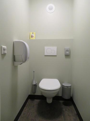 a bathroom with a white toilet in a room at Hotel Blooker in Renesse