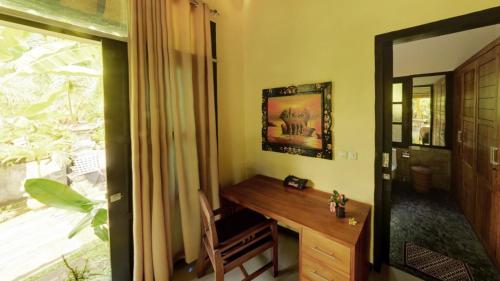 a home office with a desk and a window at Villa Latebra in Lovina