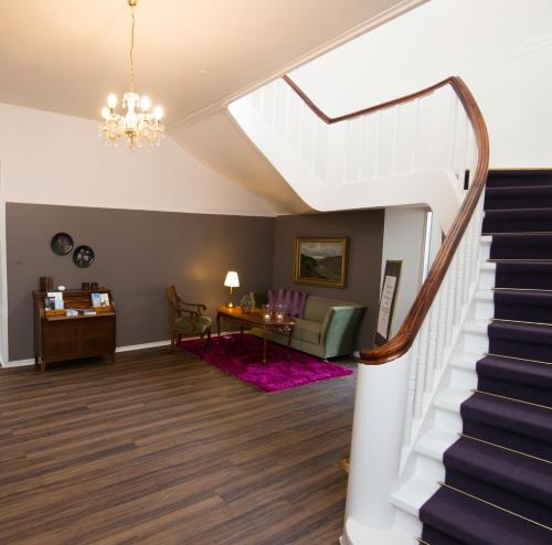 a living room with stairs and a dining room at Hotel Phønix Hjørring in Hjørring