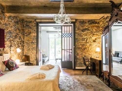 een slaapkamer met een groot bed en een stenen muur bij Chalet Saudade in Sintra