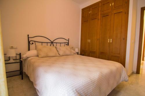a bedroom with a bed and a wooden cabinet at Apartamentos Centro 1 El Puerto de Santa Maria in El Puerto de Santa María