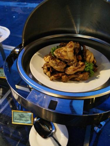 a plate of chicken and broccoli in a pot at Hype Motorsport Hotel Nilai in Nilai