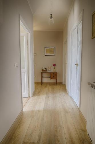 an empty hallway with a table and two white doors at La Valle del Tevere in Torrita Tiberina
