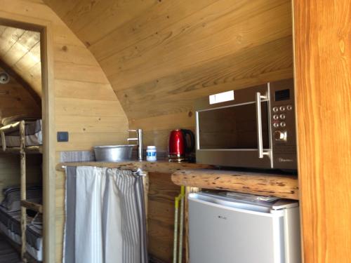 uma cozinha com um balcão, um micro-ondas e um frigorífico em La Colline Aux Cabanes em Espaly-Saint-Marcel