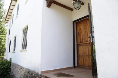une porte en bois ouverte d'un bâtiment blanc dans l'établissement Villa Lucia, à Cabezabellosa