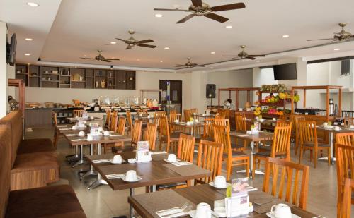 a dining room with wooden tables and chairs at Swiss-Belinn Luwuk in Luwuk