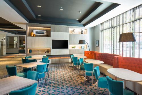 a restaurant with tables and chairs and a fireplace at Leonardo Hotel Belfast in Belfast