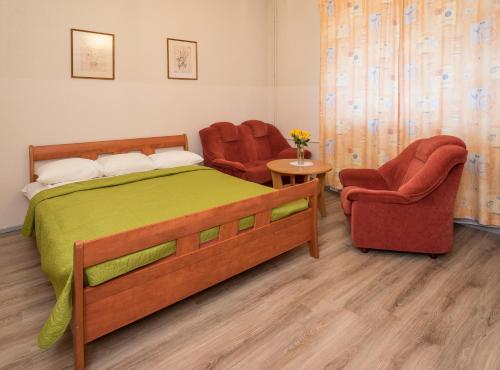 a bedroom with a bed and two chairs at Lilleküla Hotel in Tallinn