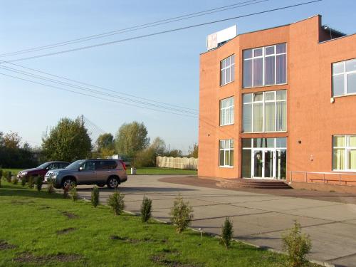 a brick building with cars parked in a parking lot at Noclegi Apro in Gdańsk