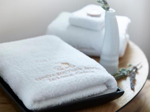 a white towel sitting on a table with a vase at Vencia Boutique Hotel in Mýkonos City