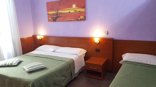 ein Schlafzimmer mit 2 Betten und einem Wandgemälde in der Unterkunft tagliaferri lucia in Rom