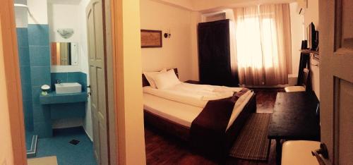 Ένα ή περισσότερα κρεβάτια σε δωμάτιο στο Hotel Casa Vlahilor