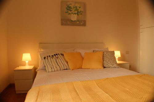 ローマにあるAppartamento Floridianaのベッドルーム1室(黄色い枕とランプ2つ付)
