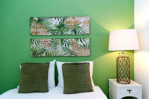 een slaapkamer met groene muren en een bed met 2 kussens bij Casa do Zézêras in Nazaré