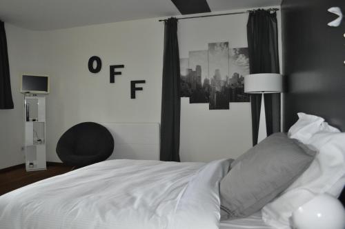 a bedroom with a white bed with a city picture on the wall at Au Cœur du Jardin in Lille