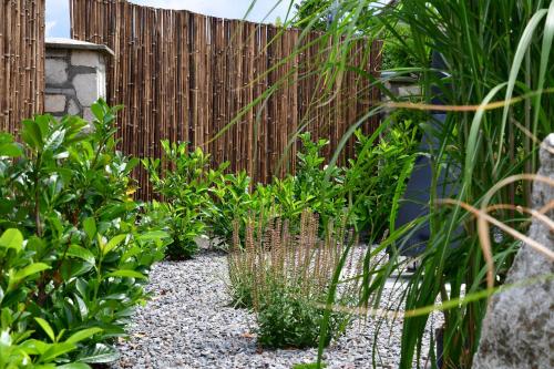 un giardino con recinzione e alcune piante di Ferienhaus Holzhaisl a Kelheim