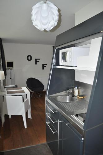 a kitchen with a sink and a table with a chair at Au Cœur du Jardin in Lille