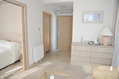 a bedroom with a bed and a dresser and a mirror at Hotel Bryza Resort & Spa in Jurata