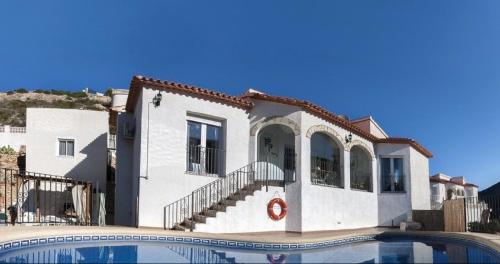 a house with a swimming pool in front of it at Villa Montesolana in Pedreguer