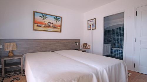 une chambre avec un lit blanc et une salle de bain dans l'établissement Villa Cavok, à Sainte-Maxime