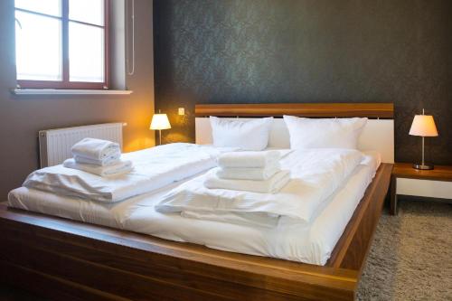 ein Schlafzimmer mit einem großen Bett mit weißer Bettwäsche und Kissen in der Unterkunft Autorenhaus Franz Kafka in Ahlbeck