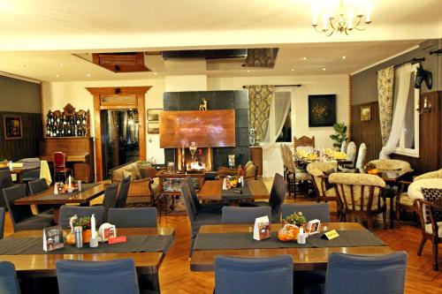 um restaurante com mesas e cadeiras e uma lareira em Hotel Jägerhof em Schluchsee