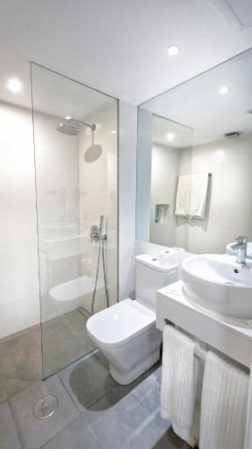 a bathroom with a toilet and a sink and a shower at Ura Hotels Jardín Del Atlántico in Playa del Ingles