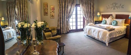 a bedroom with a bed and a table with flowers on it at Premier Hotel and Spa Cullinan in Cullinan