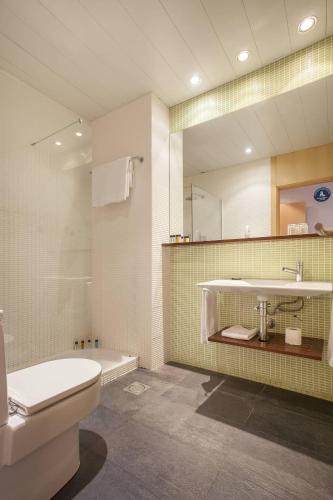 a bathroom with a sink and a toilet and a mirror at Onix Liceo in Barcelona