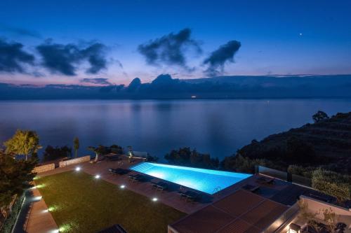 a swimming pool with a view of a lake at Kymothoe Elite Suites in Tsilivi