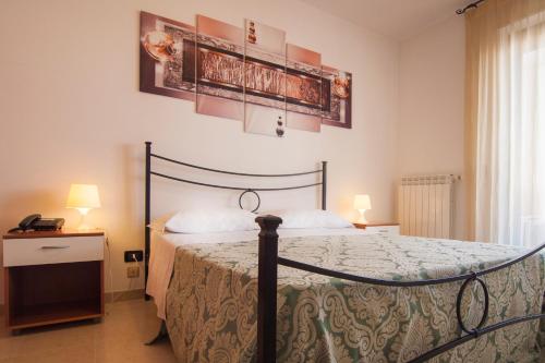 ein Schlafzimmer mit einem Bett und zwei Plakaten an der Wand in der Unterkunft Ciao Hotel & Residence in Conversano