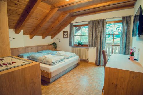um quarto com uma cama num quarto com tectos em madeira em Appartements Else em Ortisei