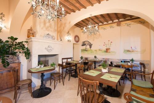 a restaurant with tables and chairs and a fireplace at Palazzo Pacini in Colle Val D'Elsa