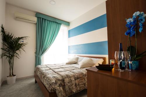 ein Schlafzimmer mit einem Bett mit einer blau-weißen gestreiften Wand in der Unterkunft Relais Vista Mare in Pozzuoli