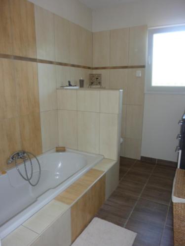 uma casa de banho branca com uma banheira e uma janela em maison zen 60m2 proche Aubenas le Baya em Ucel