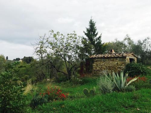 a stone building in the middle of a field at San Casciano - Appartamenti Podere Ianni in San Casciano in Val di Pesa