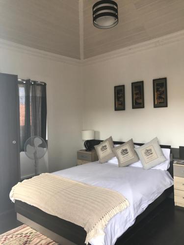 a bedroom with a bed with white sheets and pillows at Casa da Maria in Prazeres