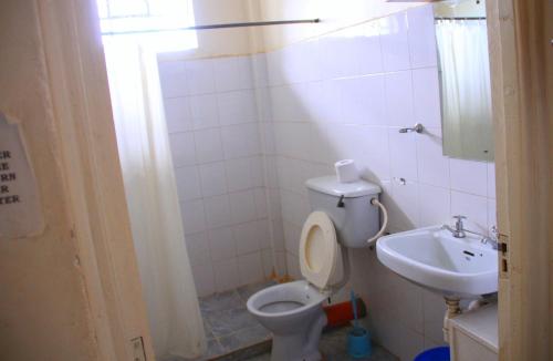a bathroom with a toilet and a sink at Sheywe Hotel Kakamega in Kakamega