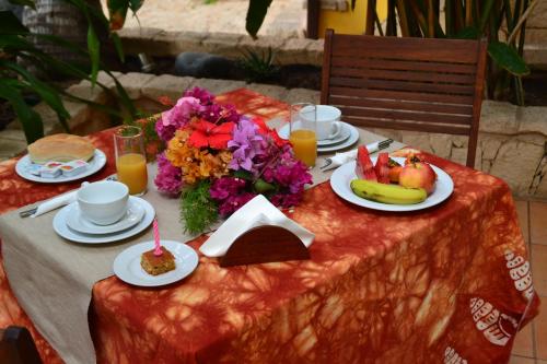 a table with plates of food and fruit on it at Guest House Orquidea in Sal Rei